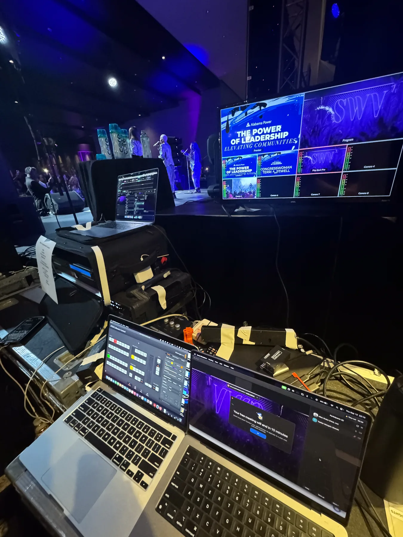 Show control position with laptops and processing gear beside the stage