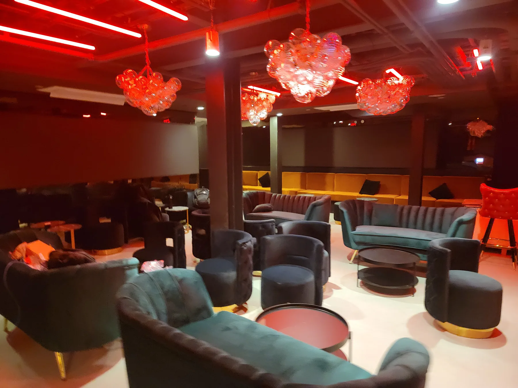 Lounge seating washed in saturated color from the surrounding screens