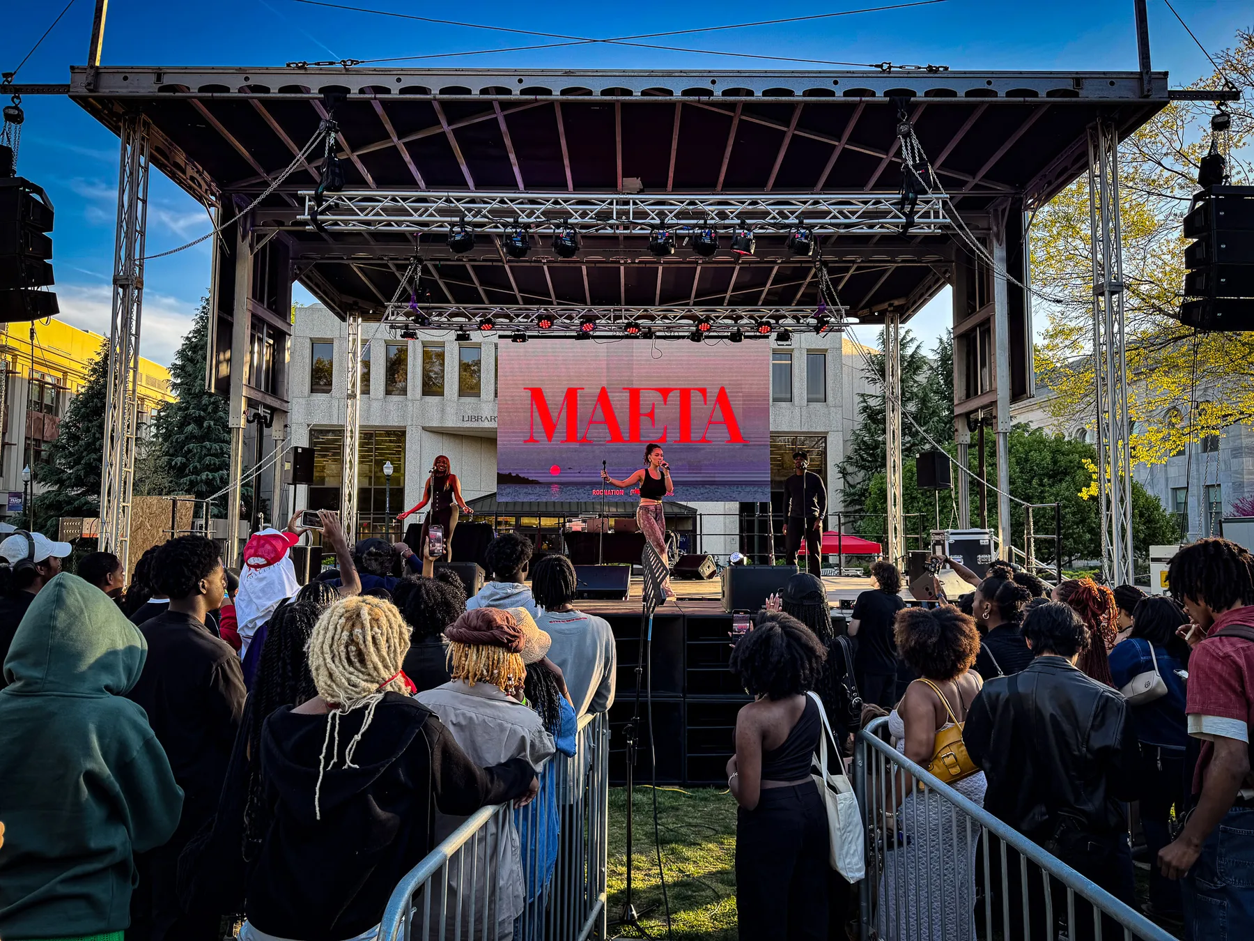 Outdoor stage and screens at dusk