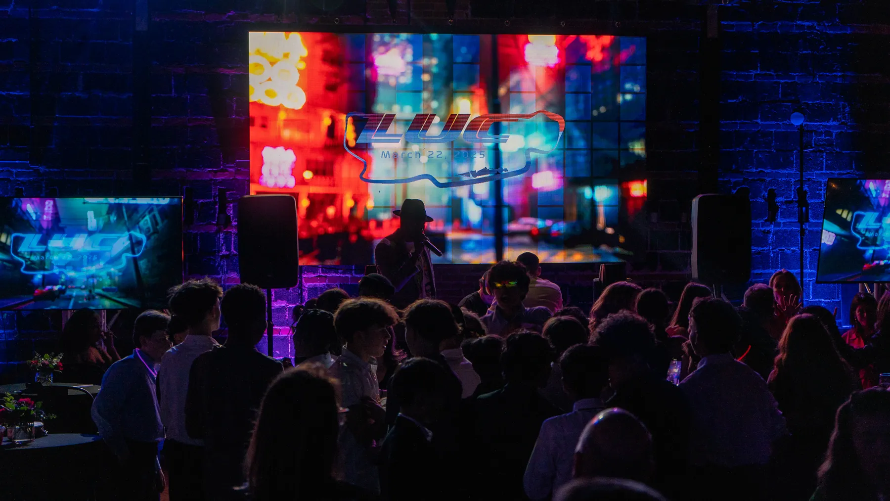 Concert crowd in front of a stage wrapped in live visuals