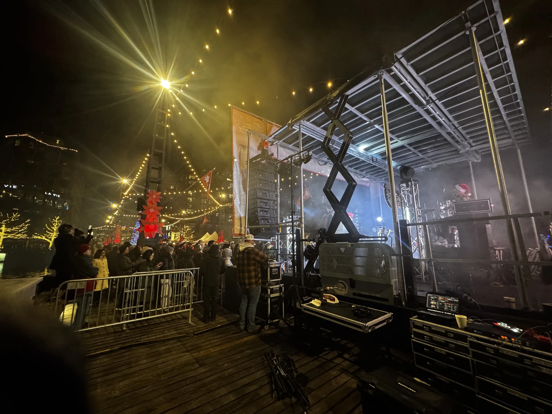 Wide view of the pier stage from the control position, with a scissor lift and the crowd