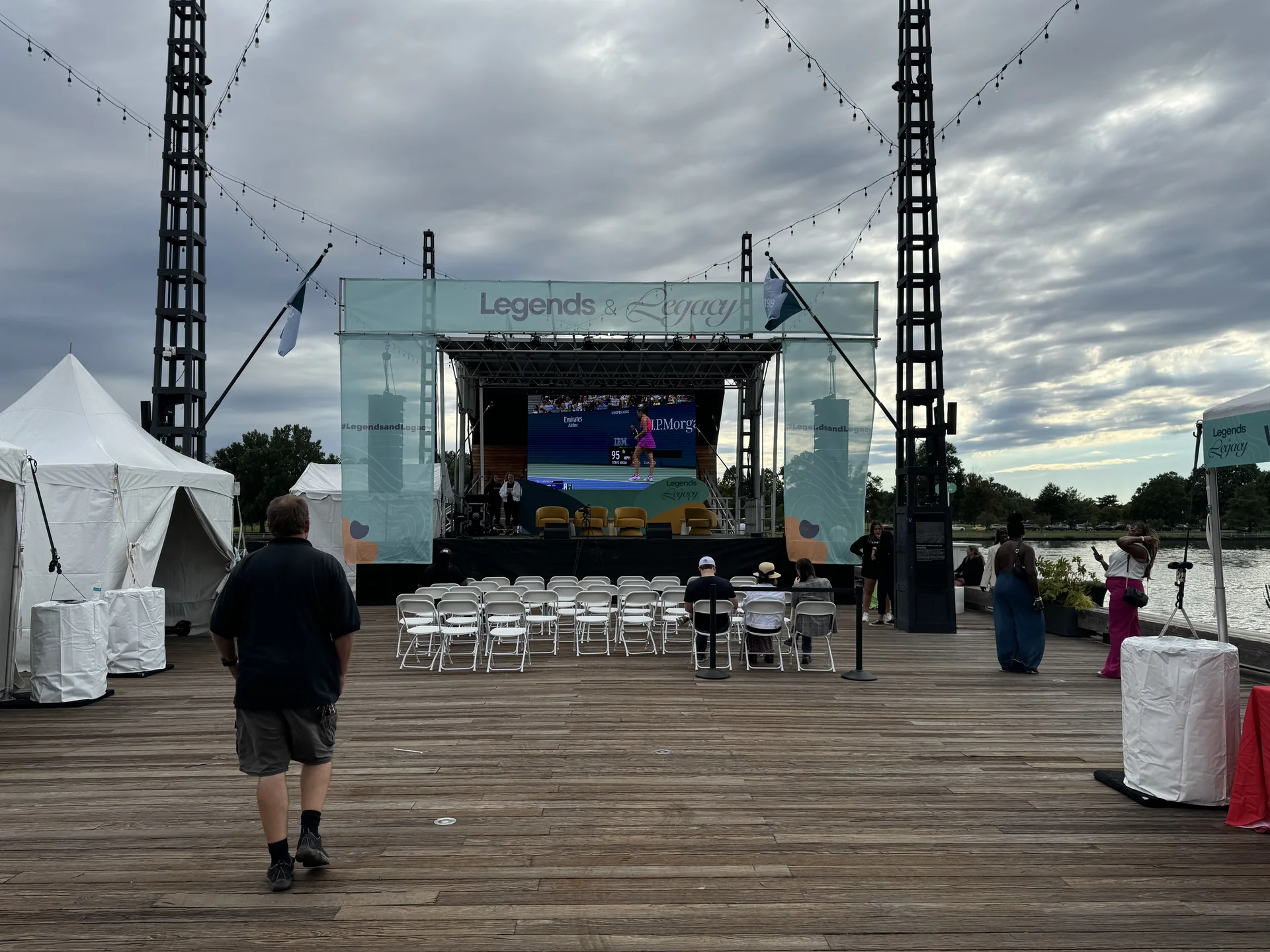 The stage with rows of white chairs set out and event banners flanking it