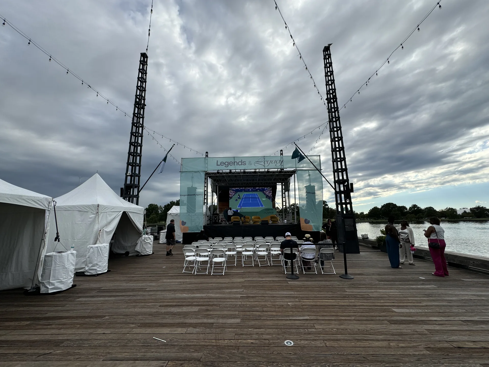 Wide view of the pier setup with tents, seating and the stage screen
