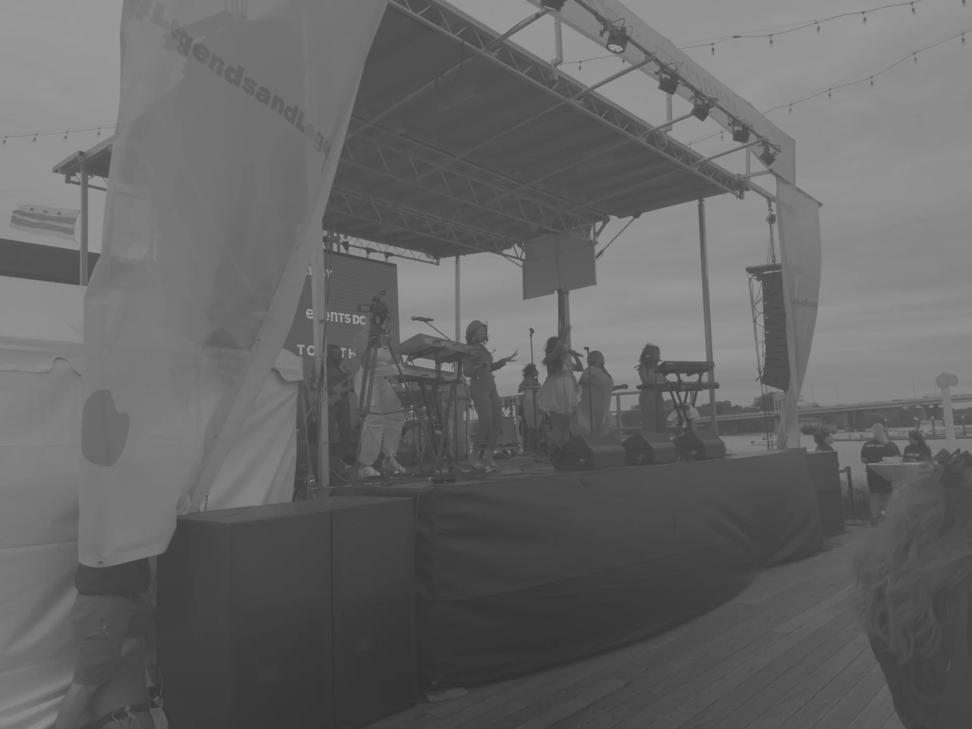 Performers on the wide stage under a cloudy sky during a level check