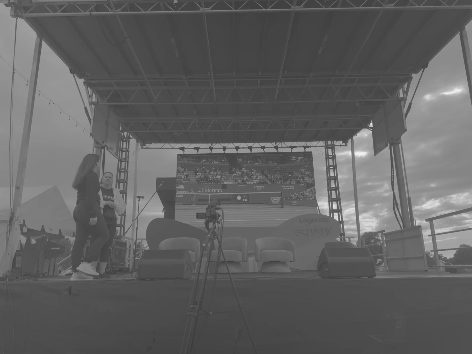 Two people setting up a camera position facing the stage