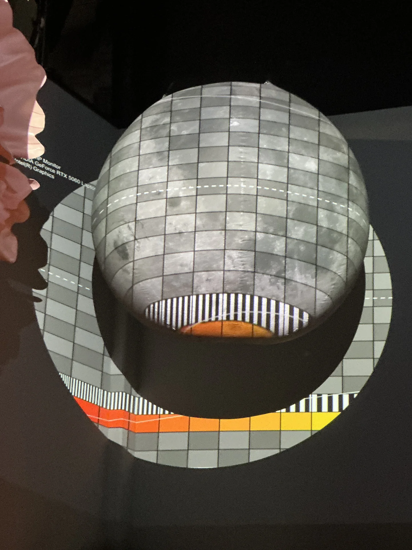 A spherical object under projection showing a checkerboard calibration grid
