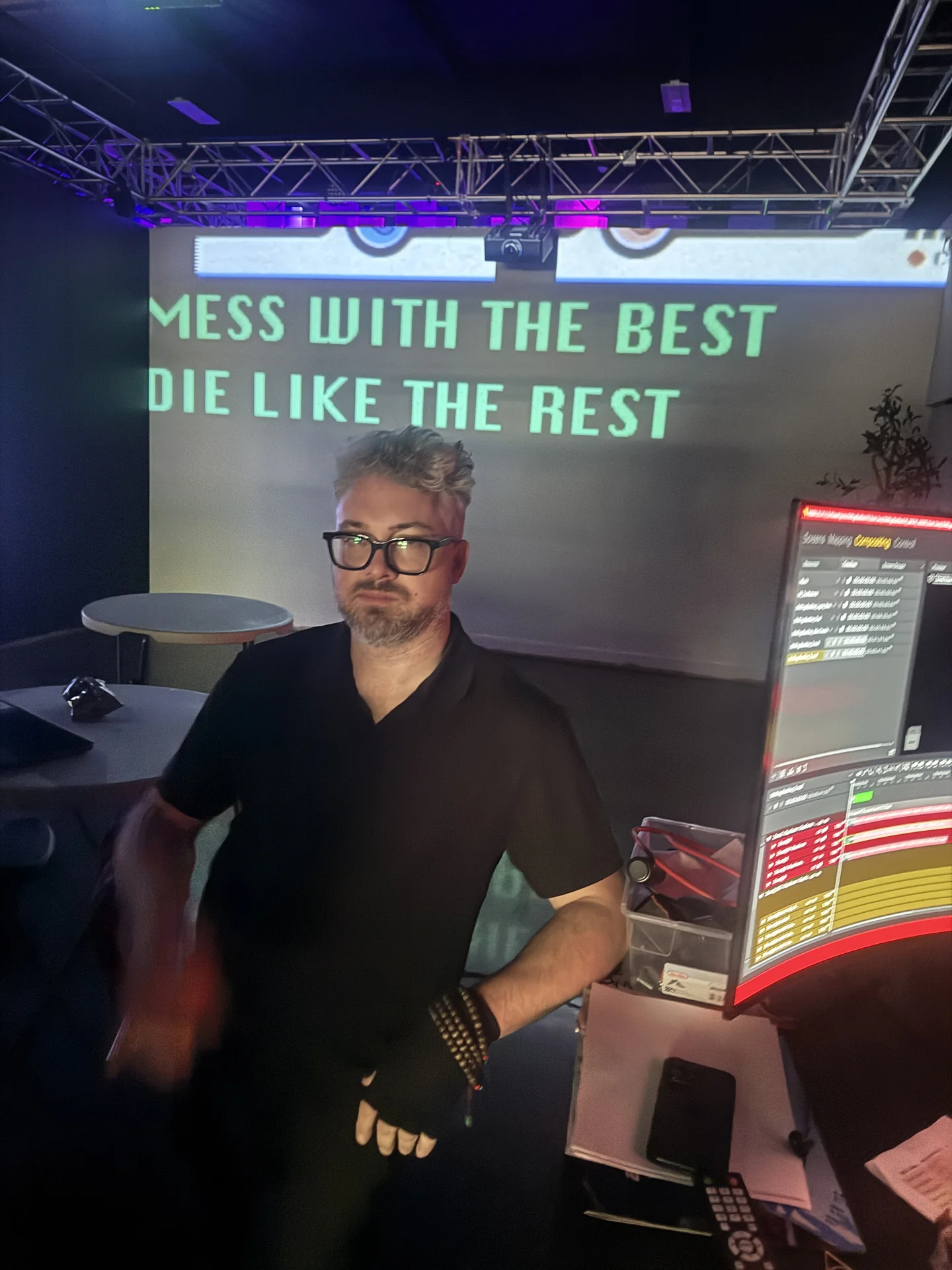A technician standing in the room in front of projected text, beside the mapping monitor